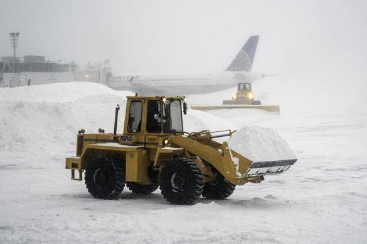 Heavy machinery clears the snow at LaGuardia Airport during a winter storm in New York January 3, 2014. REUTERS-Zoran Milich