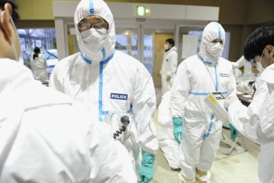 Police who have finished measuring radiation are screened for radiation contamination in Kawamata