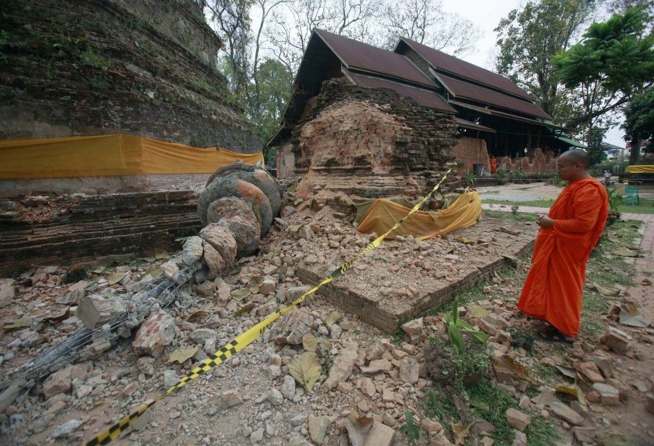 A Buddhist monk looks at a damaged pagoda after an earthquake at Wat Chedi Laung in Chiang Rai province
