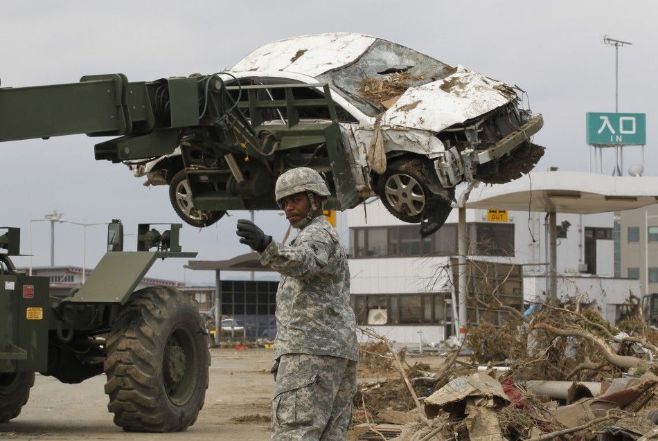 A U.S. marine based in Japan directs heavy lifting equipment as reconstruction work continues at Sendai airport 