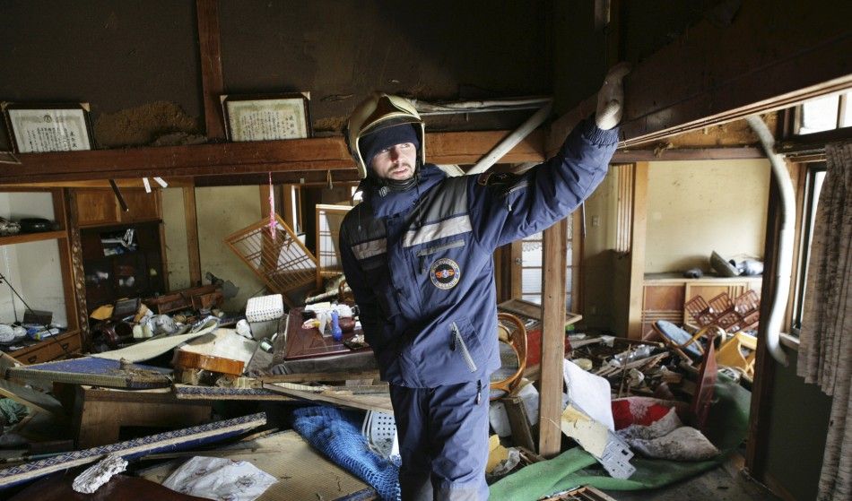 A Russian Emergencies Ministry member searches for survivors in a building damaged by the earthquake and tsunami in Sendai