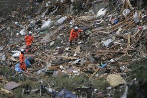 Members of Swiss Rescue team search through debris in Minamisanriku