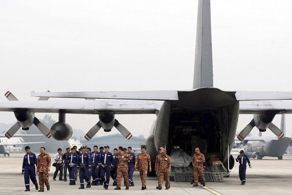 Members of the Special Malaysia Disaster Assistance and Rescue Team walk back to the terminal after loading supplies into an aircraft before leaving for earthquake and tsunami-hit Japan, at an airport in Subang