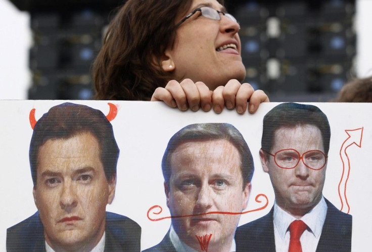 A woman holds a banner depicting Britain's Chancellor of the Exchequer George Osborne, Prime Minister David Cameron and Deputy Prime Minister Nick Clegg, at a rally in Hyde Park, in central London