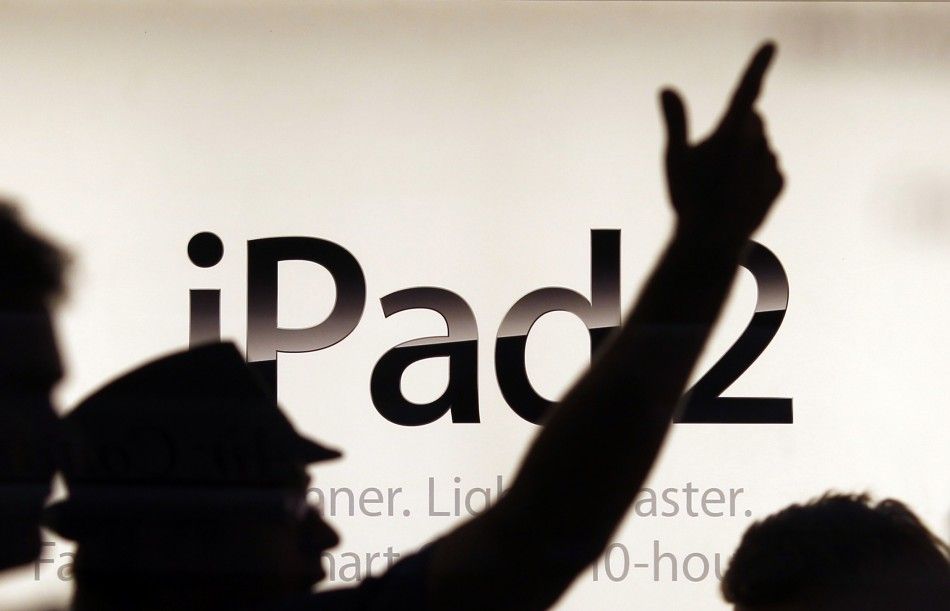 A shop assistant in Sydney gestures in front of an advertising sign moments before Apples iPad 2 became available for direct purchase in Australia 