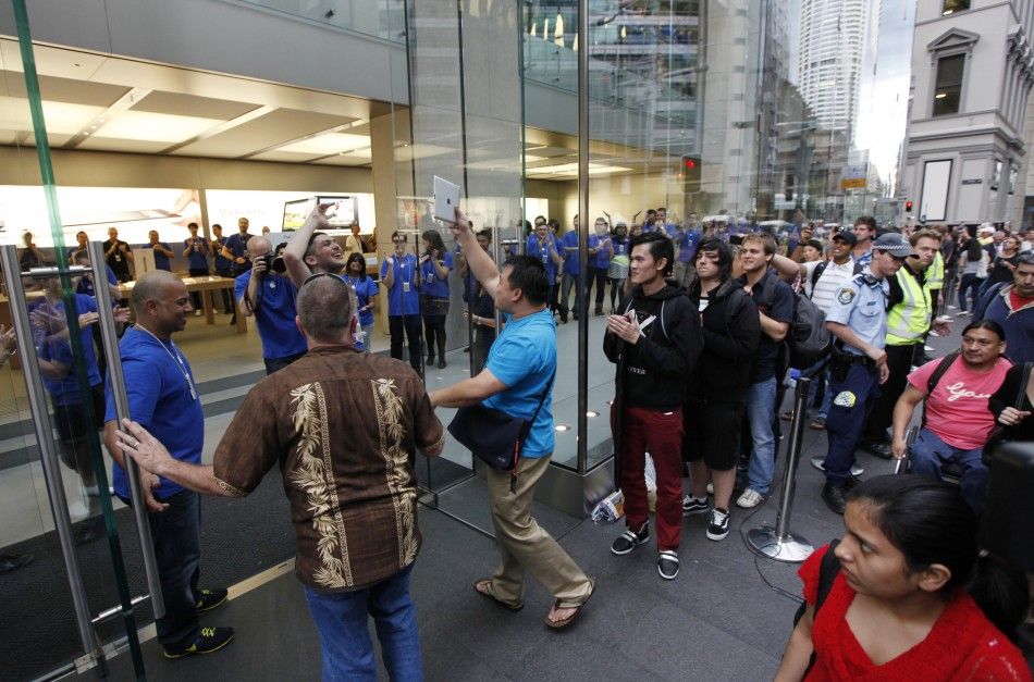 Apple store staff in Sydney welcome first shopper, Lee of Canada, the moment Apples iPad 2 became available for direct purchase in Australia