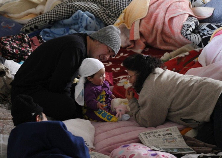 A toddler shares a light moment with her family at an evacuation centre in Yonezawa