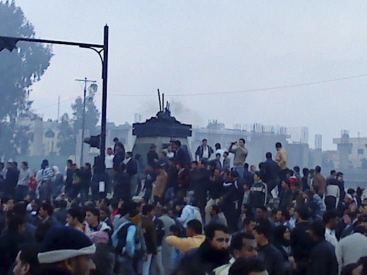 Protesters gather near the site where the statue of late Syria President Hafez al-Assad was torn down in the southern Syrian city of Deraa, in this picture taken with a mobile phone