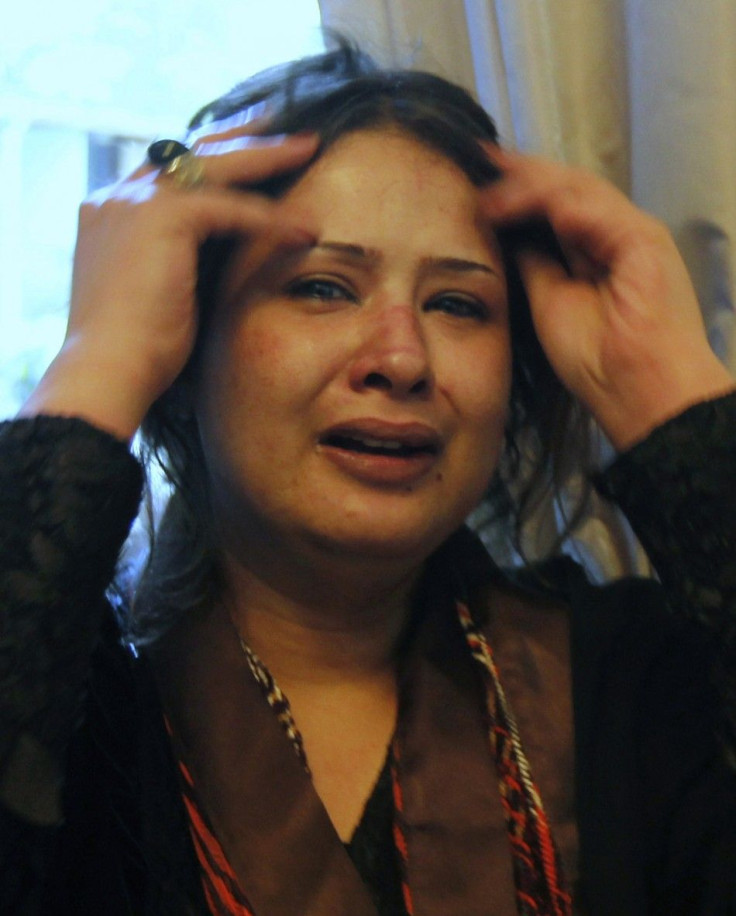 Bruises are seen on the face of Libyan woman Obaidi as she cries at a hotel in Tripoli