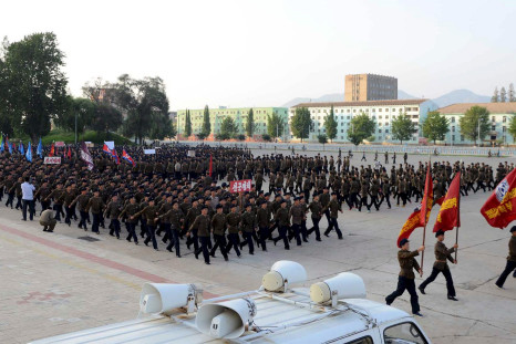 North Koreans march after signing up to the military