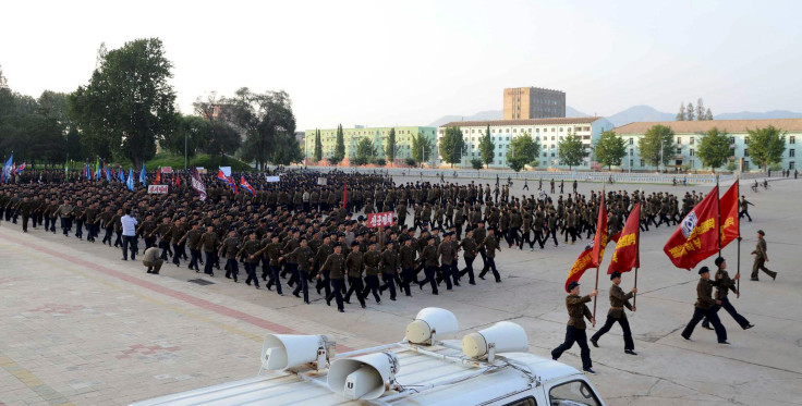 North Koreans march after signing up to the military