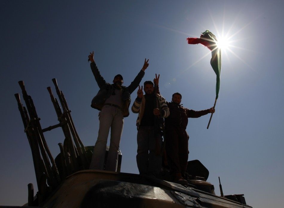 Rebel fighters celebrate on the outskirts of the town of Ajdabiyah