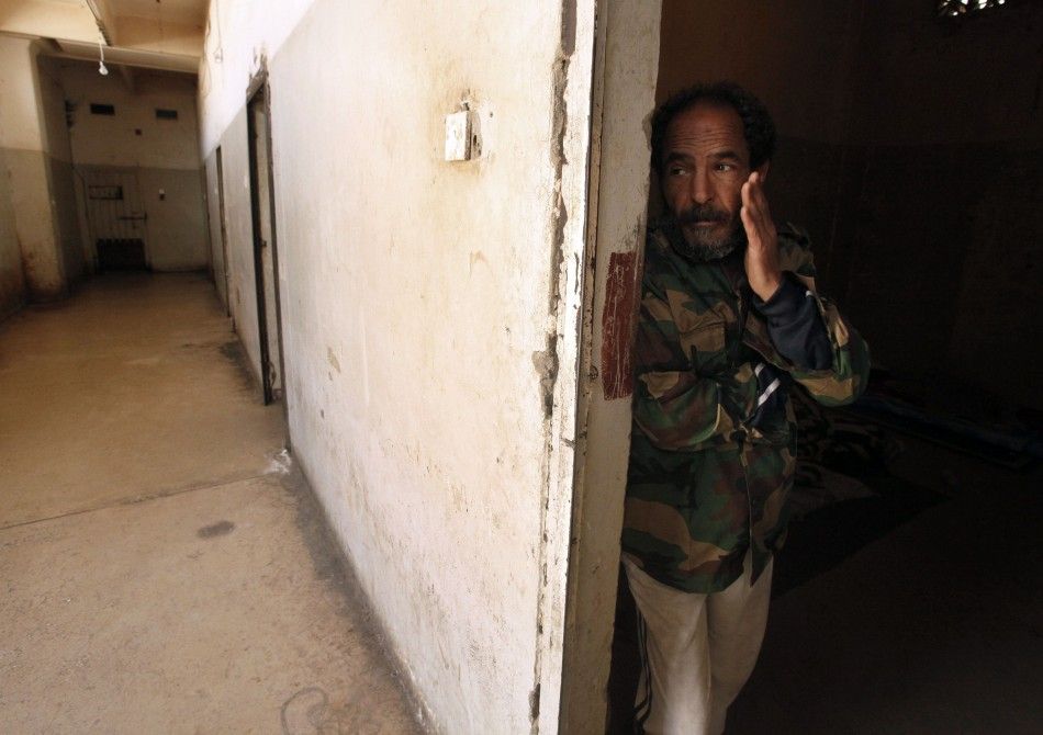 Suspected member of forces loyal to Libyan leader Muammar Gaddafi gestures inside a prison in Benghazi