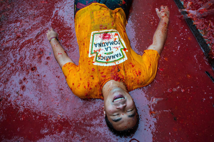 A La Tomatina participant lies in tomato sauce. 