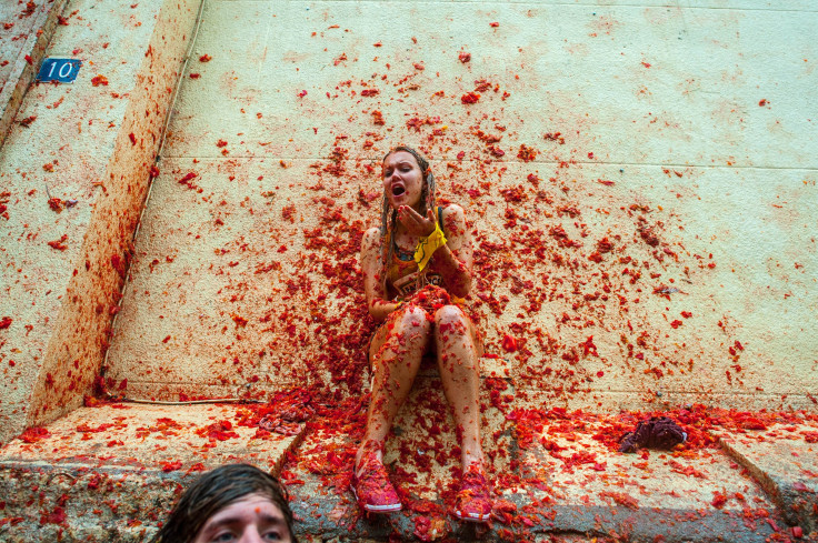 A women at La Tomatina is hit by tomatoes 