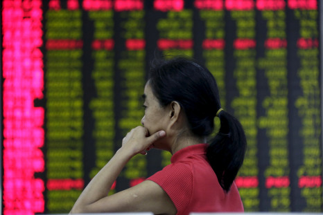 An investor at an electronic board showing stock information in Beijing 