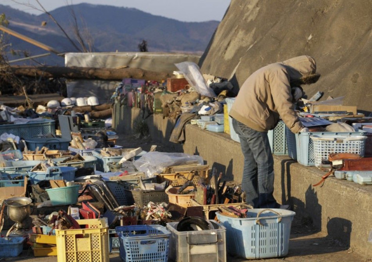 A woman cries as she looks through children's belongings near the tsunami-hit Okawa Elementary School in Ishinomaki, Miyagi Prefecture, northeastern Japan