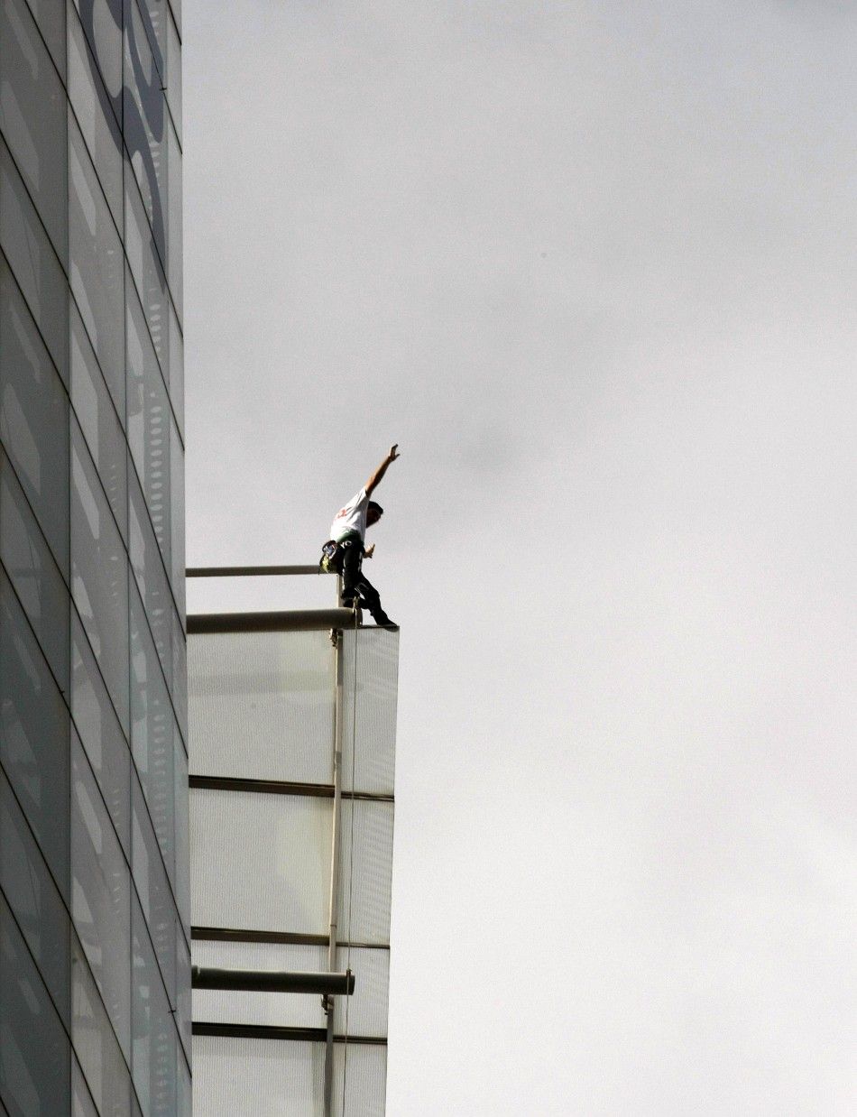 French climber Robert waves from the top of the 41-storey Aurora Place office tower in central Sydney