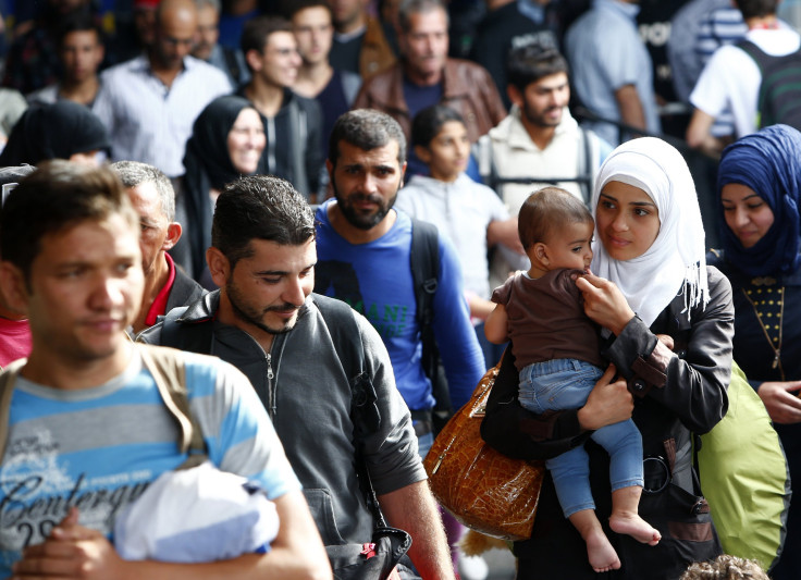 Newly arrived refugees walk along a train platform in Munich. 