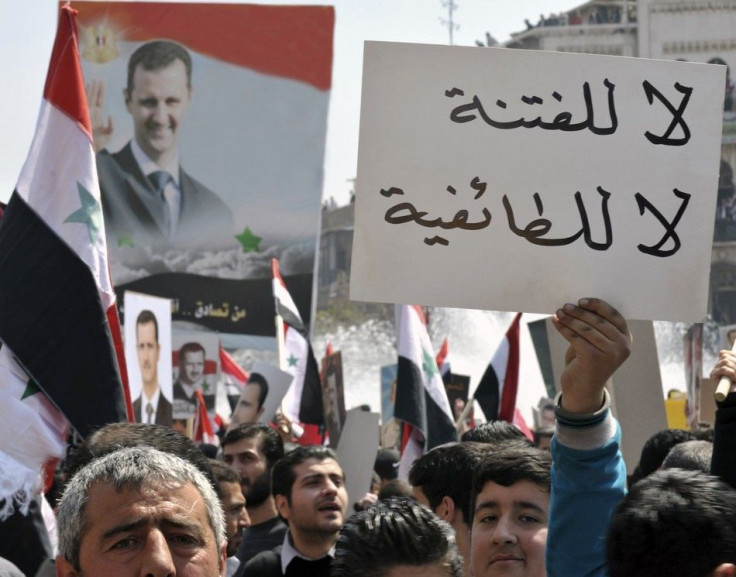 A pro-government demonstrator holds up a placard during a rally at the central bank square in Damascus