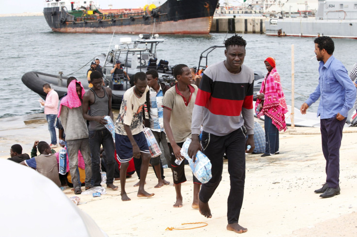 Migrants walk on to the dock in Tripoli. 