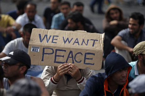 A Syrian man holds a banner asking for peace. 