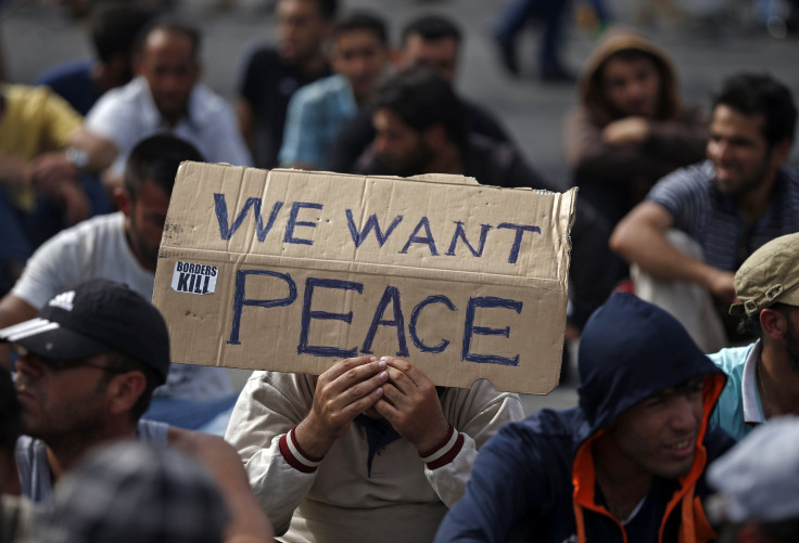 A Syrian man holds a banner asking for peace. 