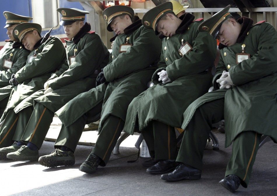 Paramilitary policemen sleep at a platform of the Guangzhou railway station