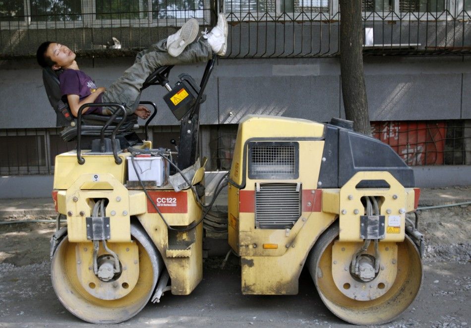 Driver takes nap on a road roller near construction site in Beijing