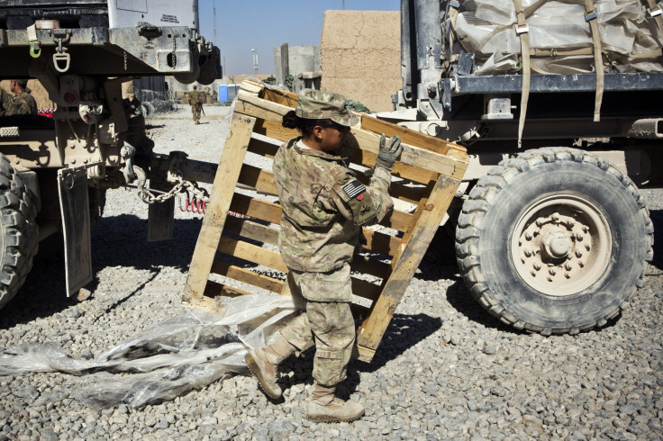 A female soldier carries a pallet passed a truck in Afghanistan