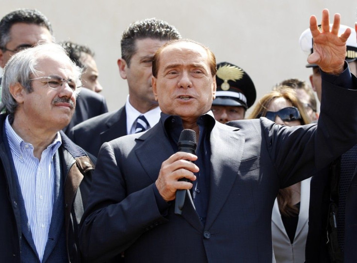 Italian PM Berlusconi speaks after arriving at at the southern Italian island of Lampedusa