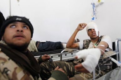 A wounded rebel fighter sits in a hospital in Ajdabiyah after being brought in from the road to Ras Lanuf, in Libya