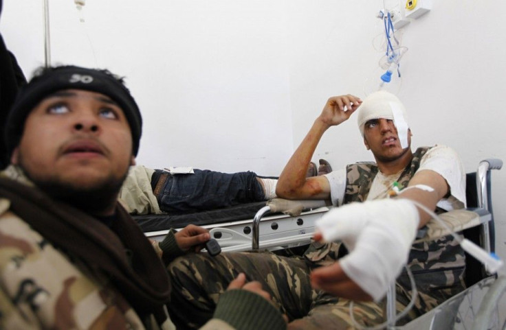 A wounded rebel fighter sits in a hospital in Ajdabiyah after being brought in from the road to Ras Lanuf, in Libya