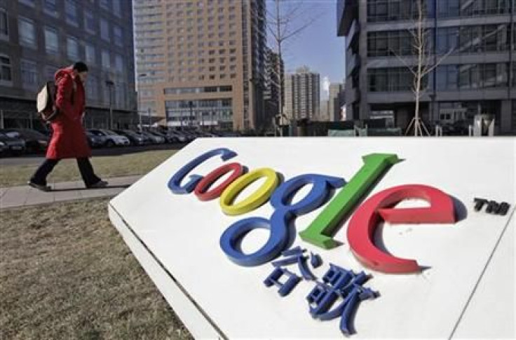 A woman walks past the logo of Google