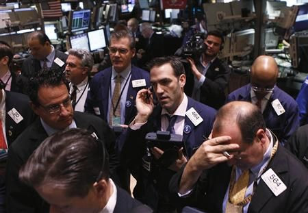 Traders work on the floor of the New York Stock Exchange while waiting for the Initial Public Offering (IPO) of shares in the company Apollo Global Management in New York