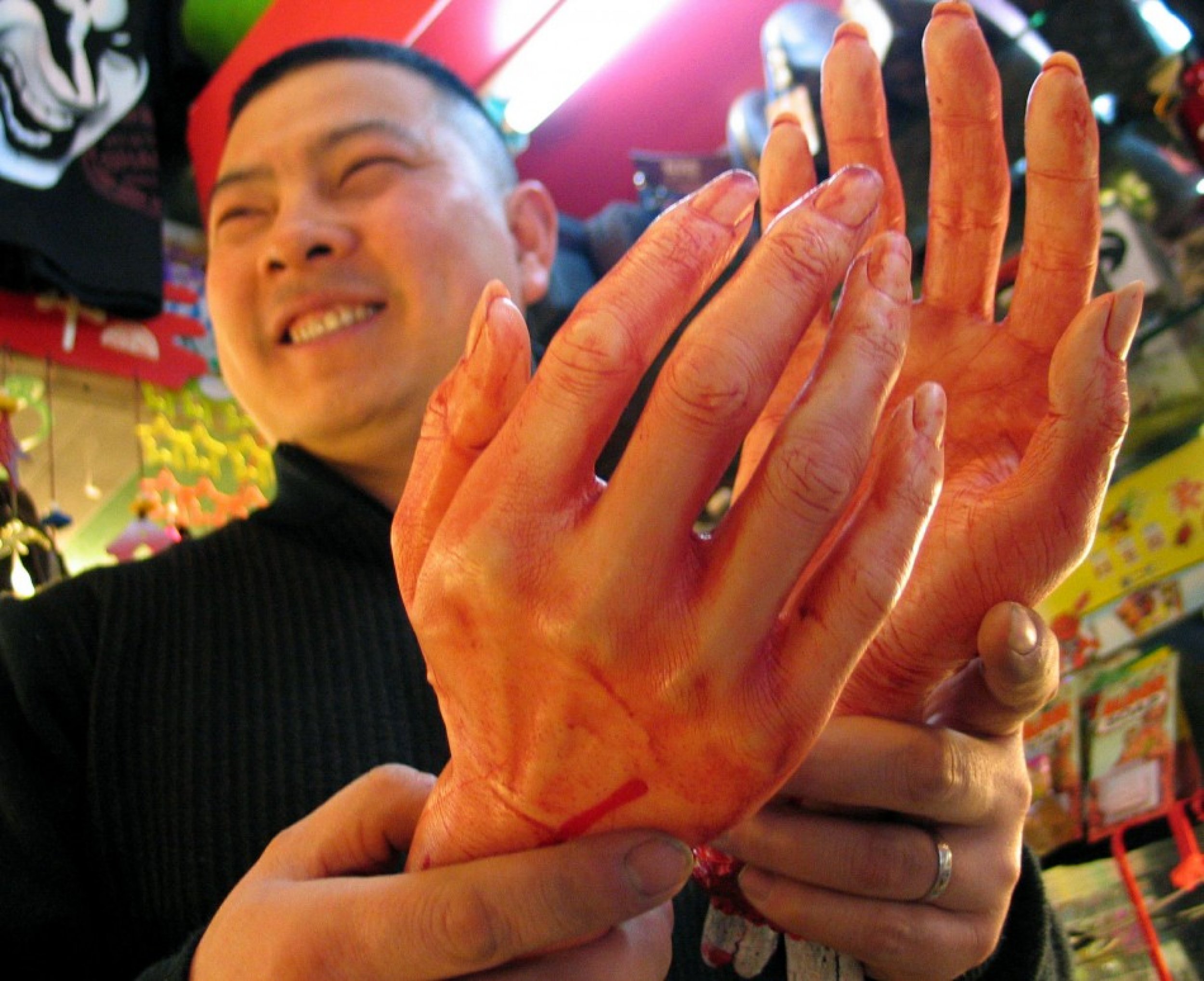 A Chinese man holds two quotbloody plastic handsquot at a toyshop that sells products for the coming April..