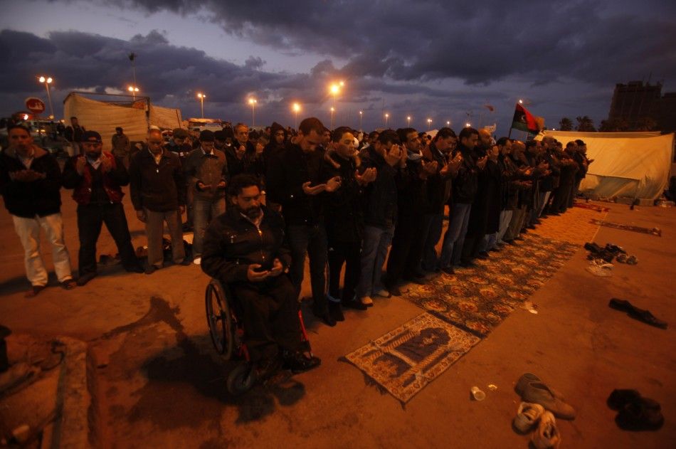 Protesters pray along a street during an anti-Gaddafi protest in Benghazi