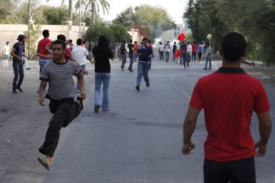 Anti-government protesters flee after riot police fire rounds of tear gas to disperse them in the mainly Shi'ite village of Diraz