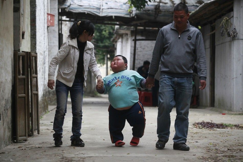Lu Zhihao walks with his parents on a street in Foshan
