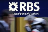 Pedestrians pass a Royal Bank of Scotland branch in central London