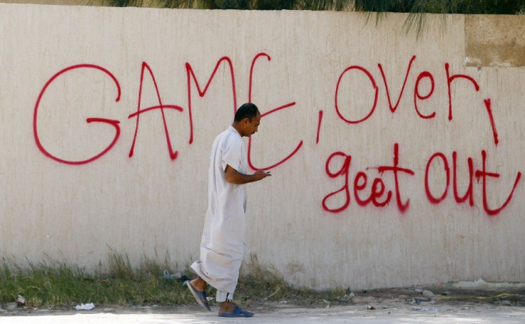 A man walks past graffiti in the town of Ajdabiyah