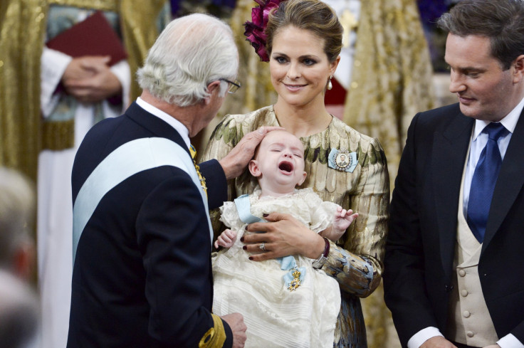 Sweden's King Carl XVI Gustaf (L-R) touches the head of Prince Nicolas held by Princess Madeleine as Christopher O'Neill looks on
