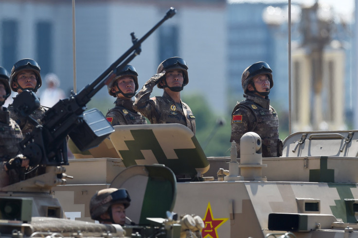 Chinese soldiers ride in a armored vehicle.