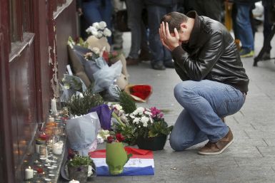 A man weeps as he pays his respects outside a restaurant in central Paris 