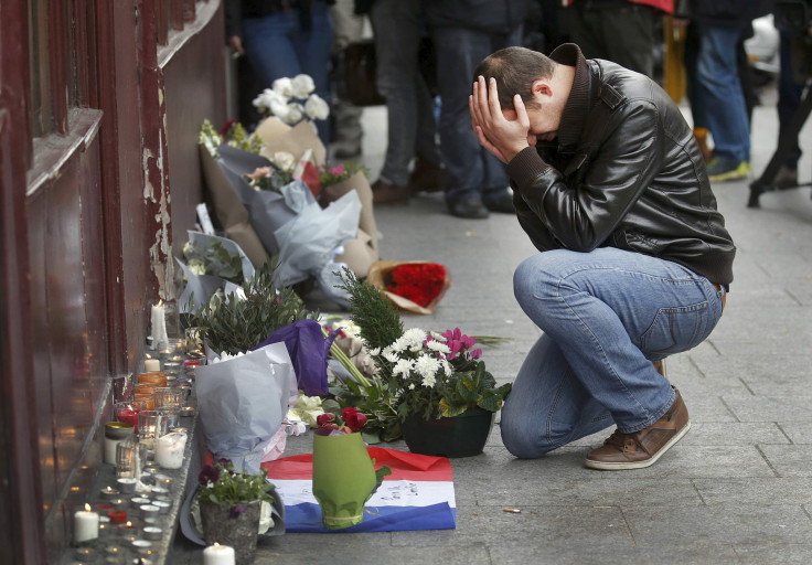 A man weeps as he pays his respects outside a restaurant in central Paris 