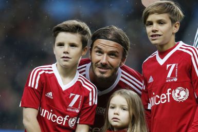 David Beckham and his children Cruz, Romeo and Harper pose before a charity football match