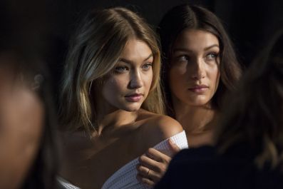 Models Gigi Hadid (L) and Bella Hadid pose for photos backstage before the Tommy Hilfiger Spring/Summer 2016