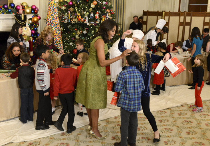 First Lady Michelle Obama (C) chats with children of military families as they gather to enjoy holiday decorations and treats