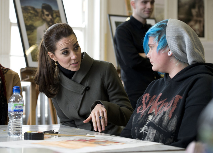 Britain's Catherine, Duchess of Cambridge (L), speaks to young people as she visits a photographic exhibition