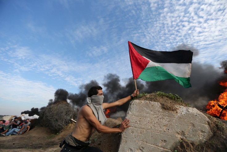 A protester plants a flag during clashes with Israel 